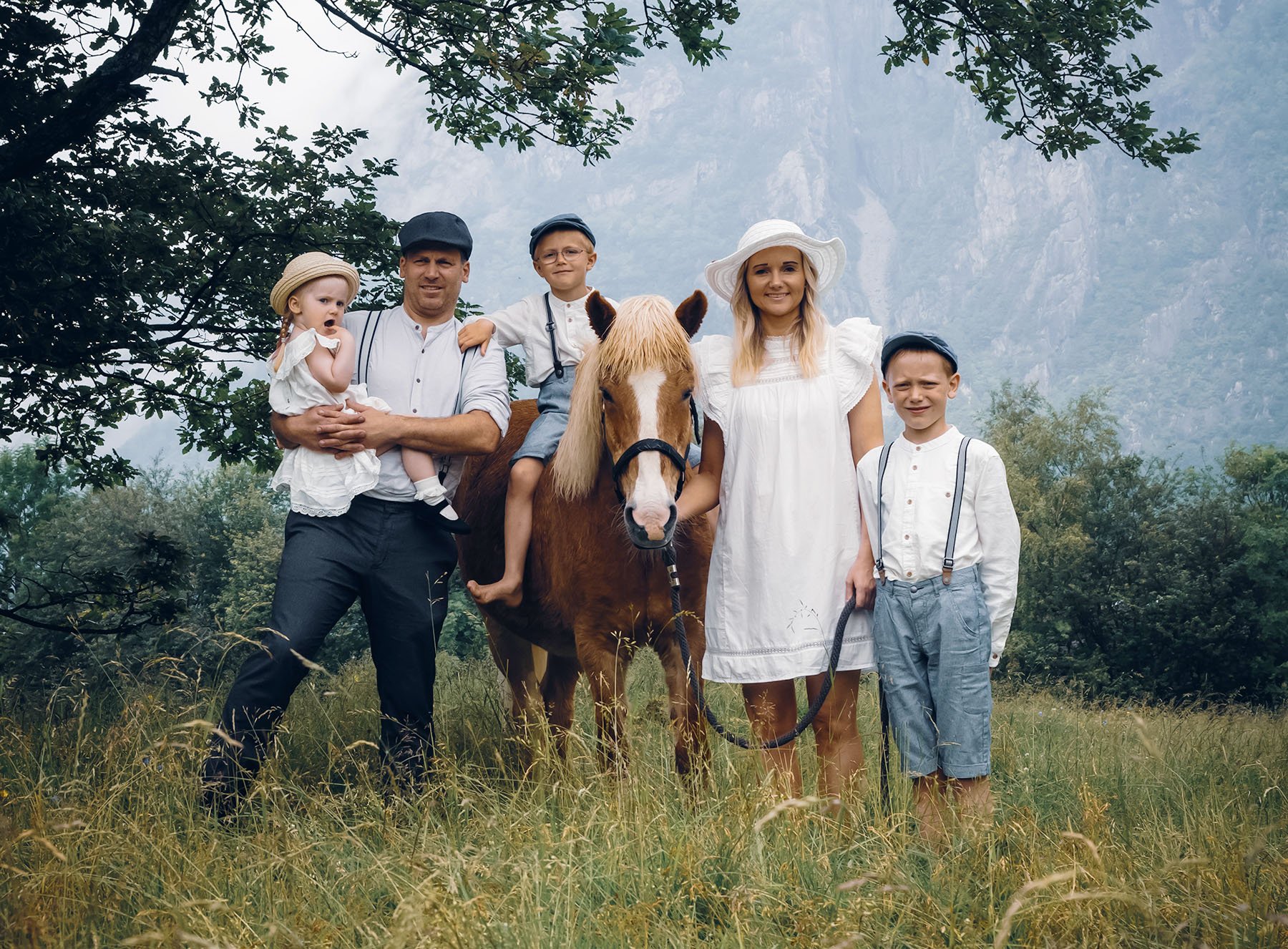 Foto: Familien Hommeland og en hest i en eng.